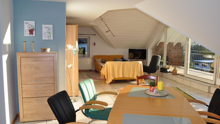 Eine helle und gemütliche Dachgeschosswohnung mit modernen Möbeln. Der Essbereich bietet einen schönen Blick auf die Umgebung.