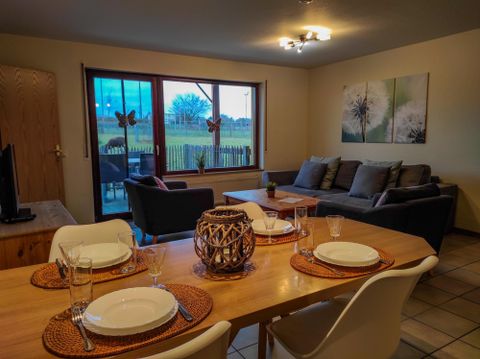 Ein einladender Bauernhof in der Eifel mit Blick auf Kühe und grüne Landschaft. Gemütliche Ferienwohnungen bieten eine perfekte Gelegenheit für einen Natururlaub.