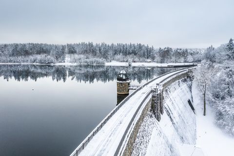 Winterliche Dreilägerbachtalsperre mit verschneiter Landschaft und ruhigem Wasser.