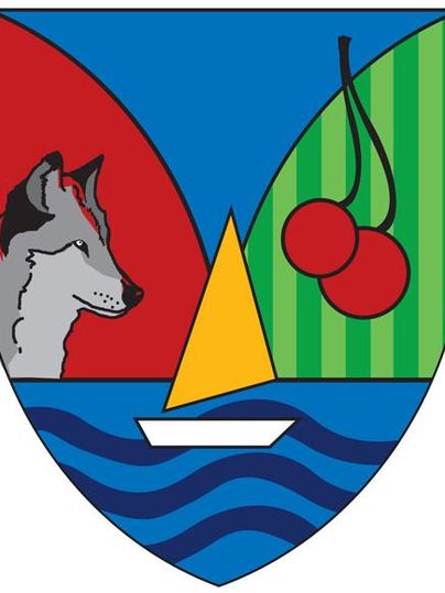 Ein Wappen mit einem Wolf, einem Segelboot und zwei Kirschen. Die Farben sind rot, grün und blau, mit Wellen im unteren Bereich.