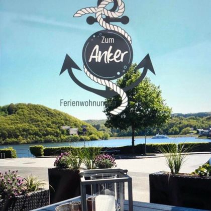 Eine moderne Wohnung mit einer offenen Küche und einem gemütlichen Wohnbereich. Die Möbel sind in neutralen Farben gehalten, mit zwei kleinen Tischen in der Mitte.