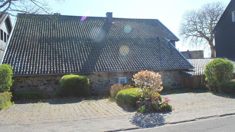Ein charmantes Haus mit einem Satteldach und einer schönen Gartenlandschaft. Die Umgebung ist ruhig und einladend, ideal für entspannte Spaziergänge.