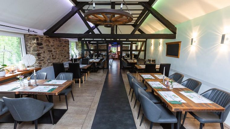 Ein modernes Restaurant mit Holzdekor und eleganten Tischen. Die Atmosphäre ist einladend und hell.