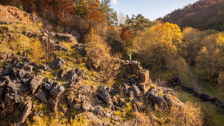 Herbstliche Landschaft mit Felsen und Bäumen in einem Steinbruch bei Niederehe am Eifelsteig.